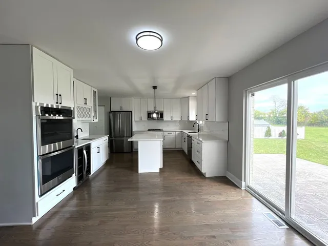 a kitchen with stainless steel appliances a stove top oven and a sink