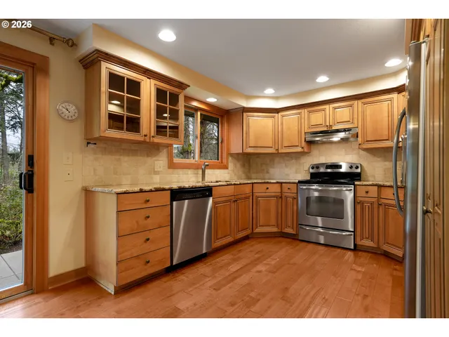 a kitchen with granite countertop white cabinets and stainless steel appliances