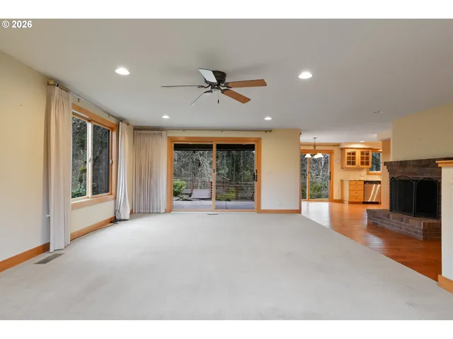 a view of an empty room with window and fire place