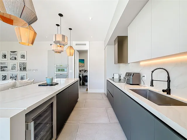a large kitchen with stainless steel appliances lots of counter space and a sink
