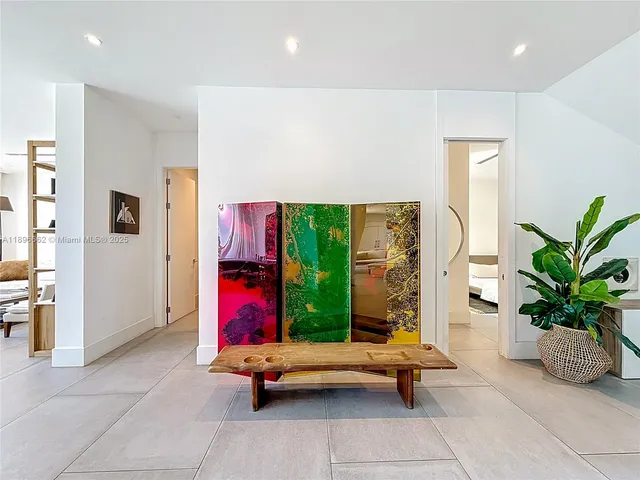 a living room with furniture flowers and a large window
