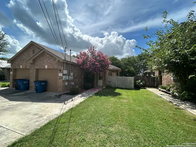 a front view of house with yard and trees in the background