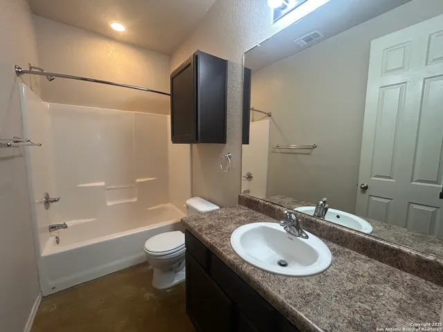 a bathroom with a granite countertop sink toilet and shower