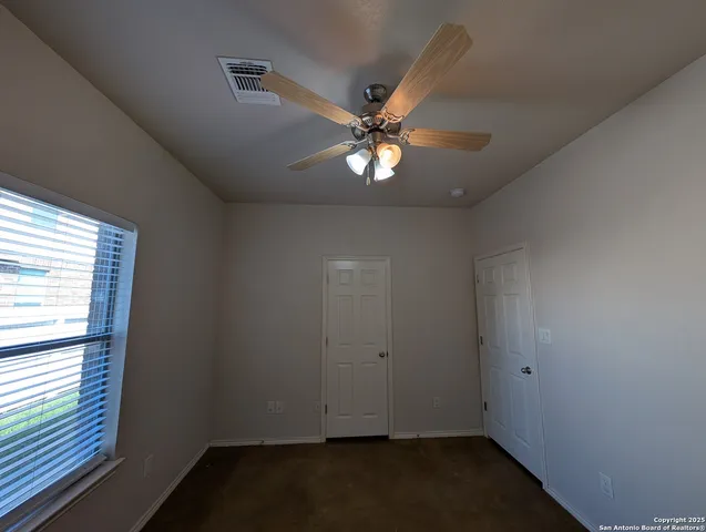 en empty room with windows and fan