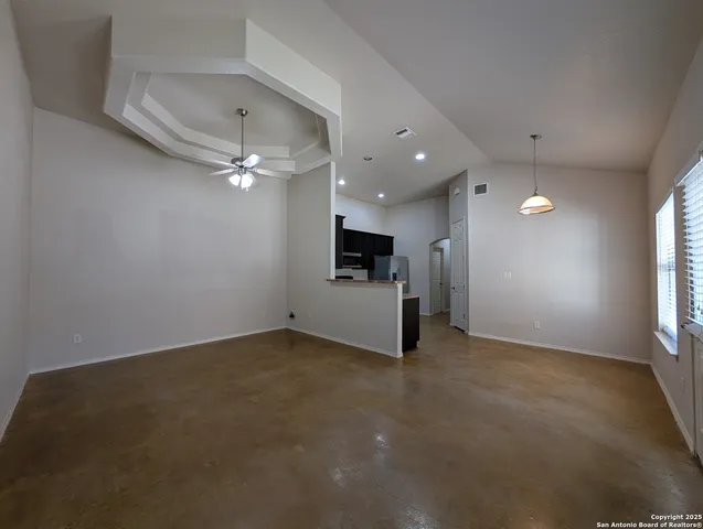 an empty room with a fireplace and windows