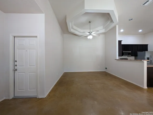 an empty room with a ceiling fan and a projector view