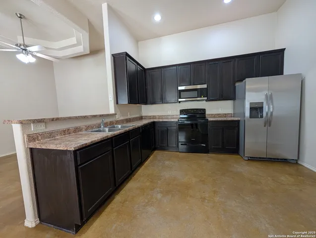 a kitchen with stainless steel appliances granite countertop a refrigerator and a sink