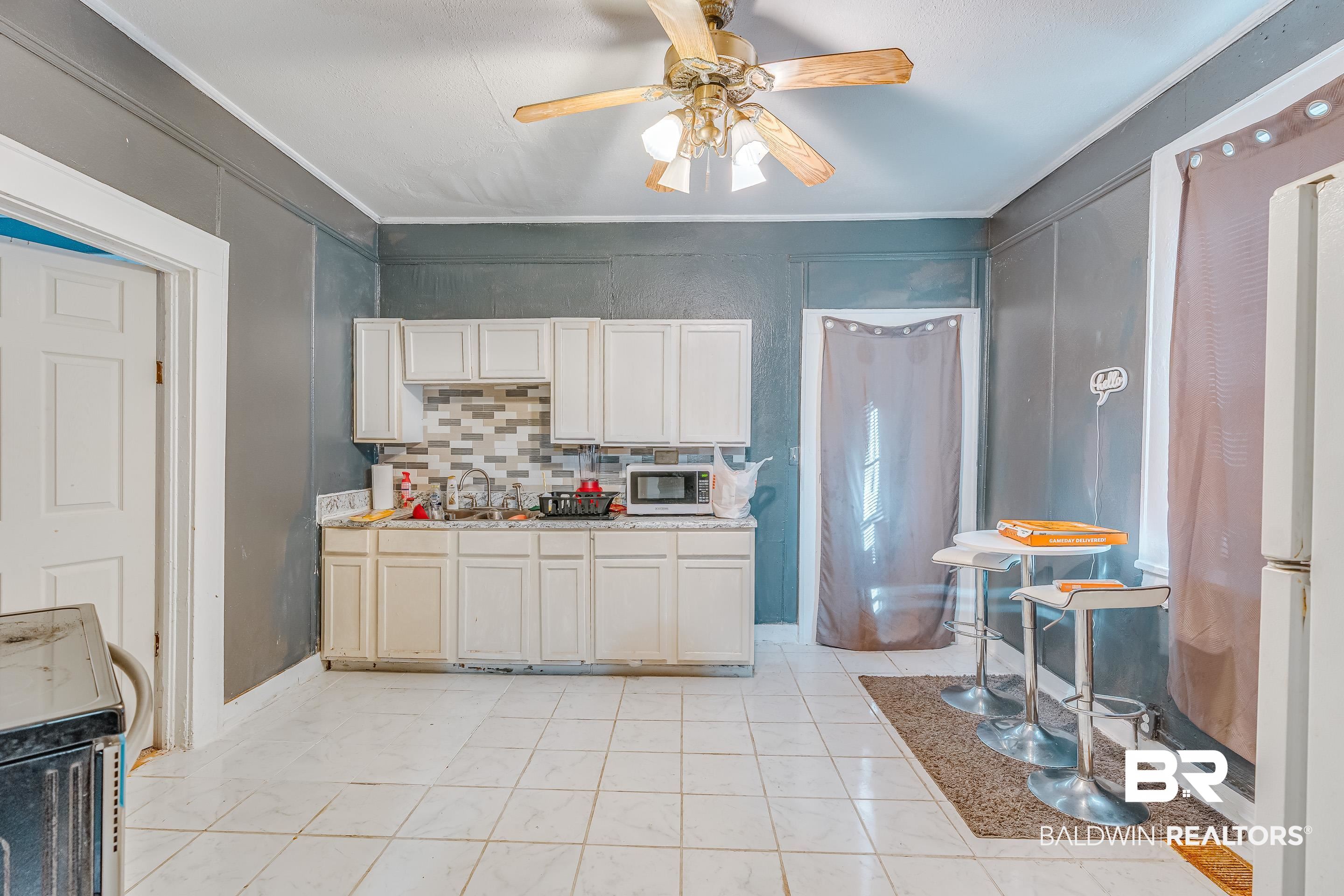 14 Southern Street Mobile, AL 36611 - Photo 6 of 26 Kitchen with crown molding, tasteful backsplash, electric range oven, and white cabinets