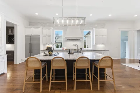 a kitchen with cabinets wooden floor dining table and chairs