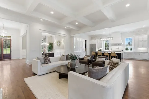 a kitchen with stainless steel appliances granite countertop a table chairs stove and refrigerator