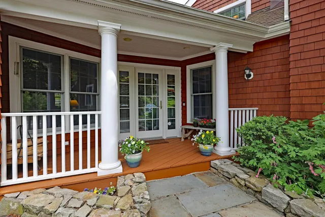 a view of a house with a chair and flower potted plant