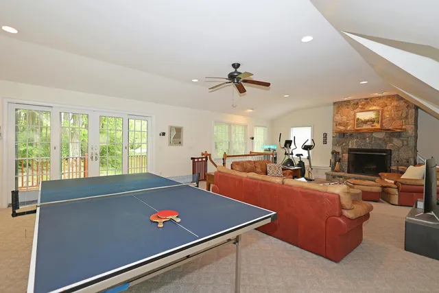 a living room with furniture pool table and a fireplace
