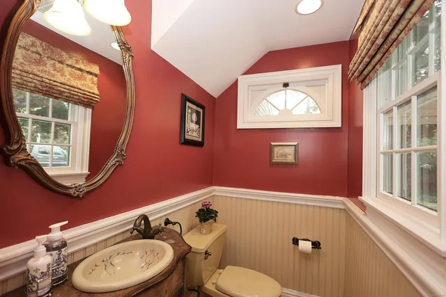 a bathroom with a toilet a sink and mirror