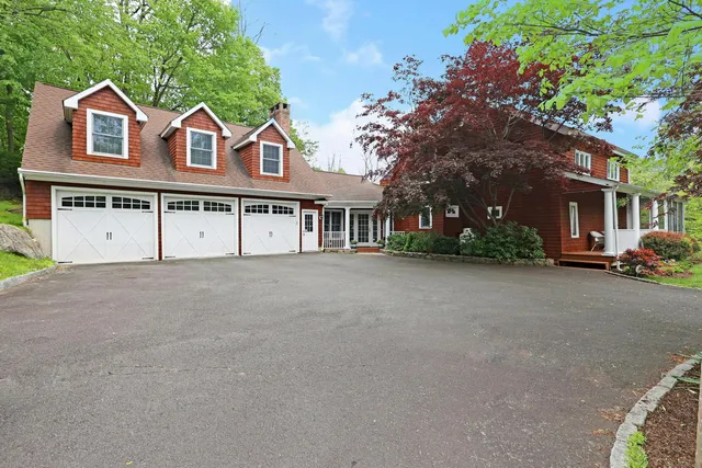 a view of a white house with a large windows and a tree