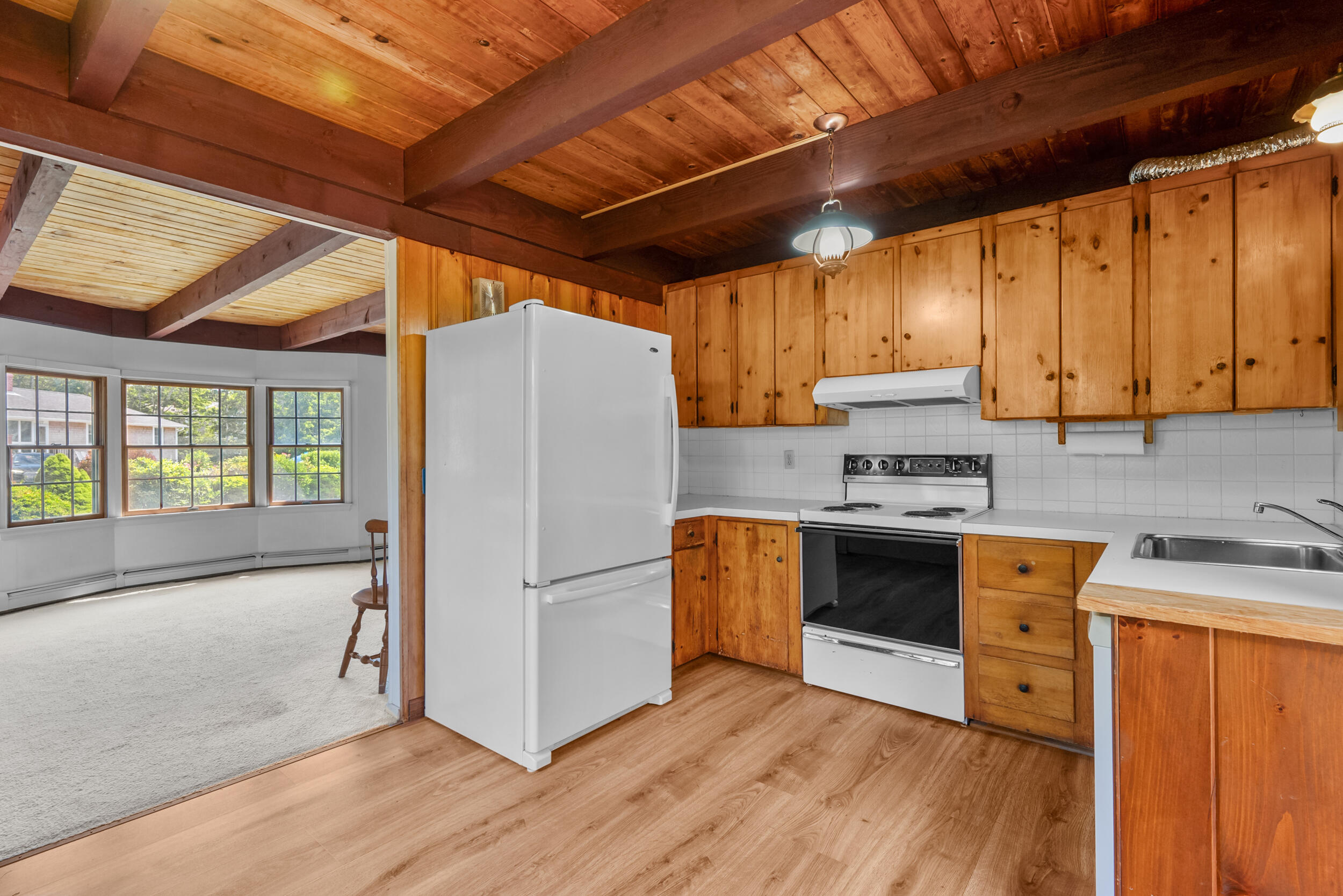 114 Bucks Creek Road Chatham, MA 02633 - Photo 11 of 43 a kitchen with stainless steel appliances granite countertop a refrigerator a sink dishwasher a stove and white countertops with wooden floor