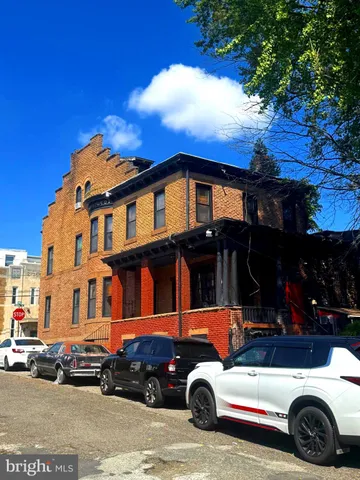 a front view of a house with a tree