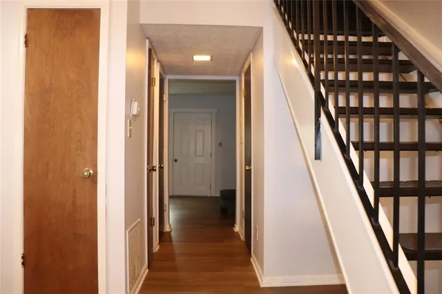 a view of a hallway with wooden floor and staircase