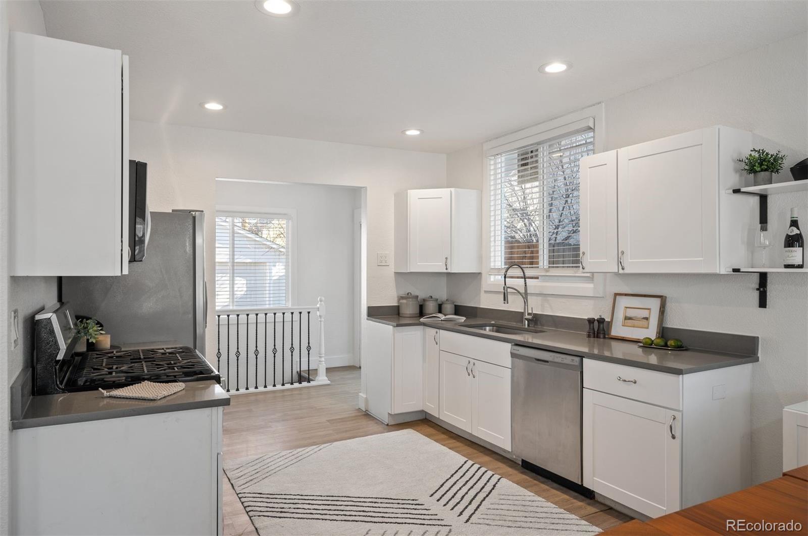 1422 Quebec Street Denver, CO 80220 - Photo 4 of 19 a kitchen with a sink stove top oven and cabinets