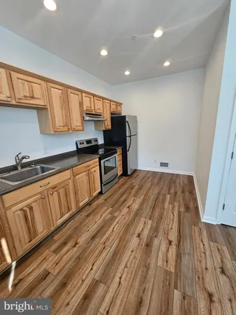 a kitchen with wooden floors and a sink