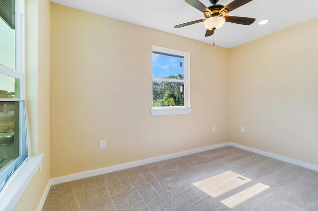 an empty room with a window and a fan