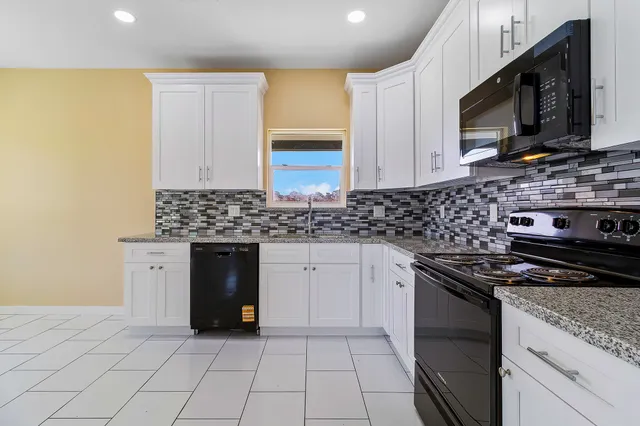 a kitchen with stainless steel appliances granite countertop a stove a sink and a microwave