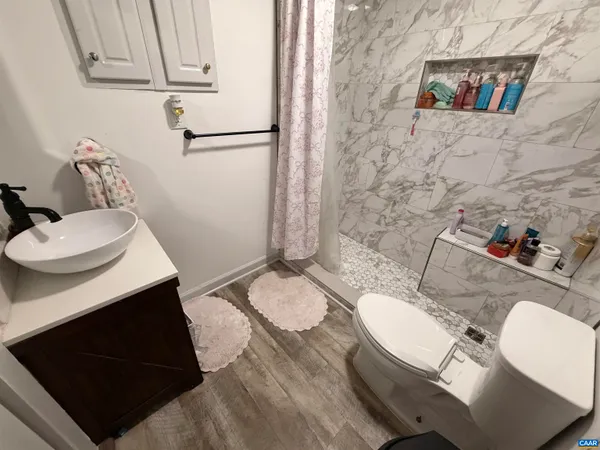 a bathroom with a sink a toilet and shower