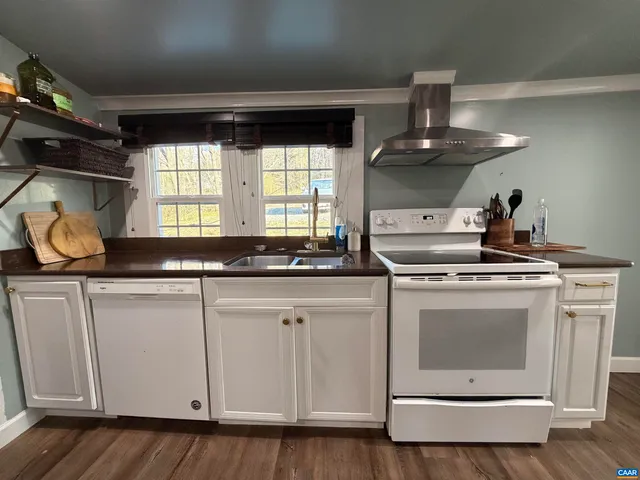 a view of a hallway with wooden floor and a chandelier