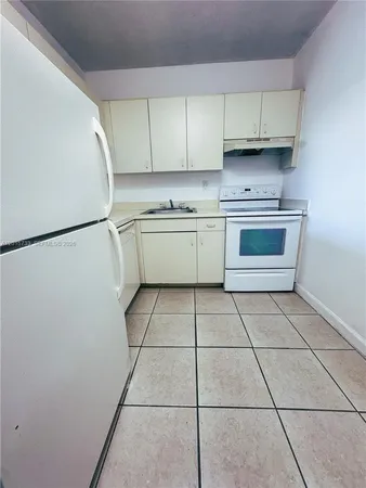 a kitchen with a white cabinets and white appliances