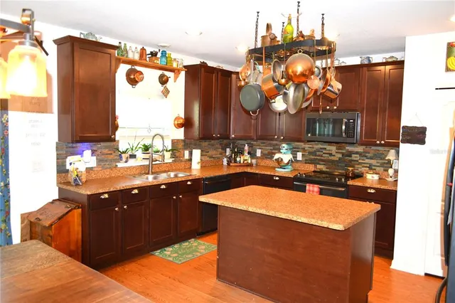 a kitchen with stainless steel appliances granite countertop a sink and a stove