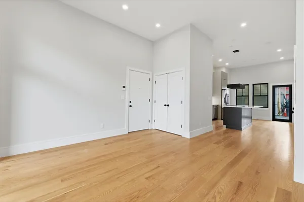 a view of a big room with wooden floor and windows