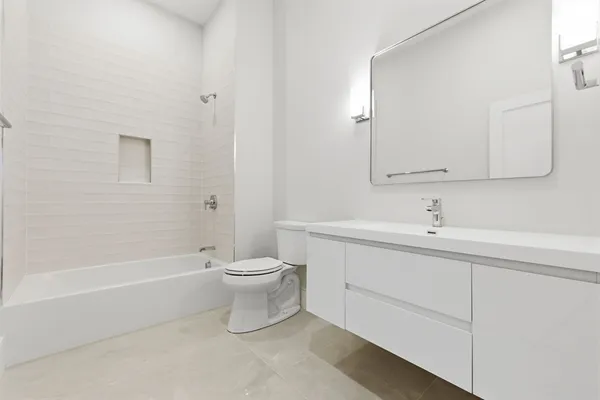 a bathroom with a toilet a sink a mirror and bathtub