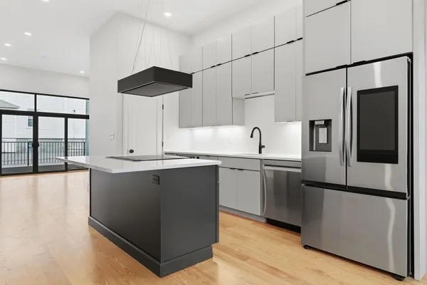 a kitchen with stainless steel appliances granite countertop a refrigerator a sink and a stove