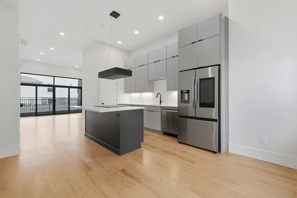 a kitchen with stainless steel appliances granite countertop a refrigerator a sink and a stove