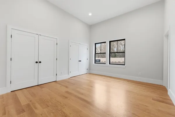 a view of an empty room with window and closet area