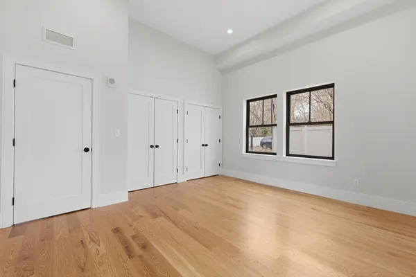 a view of an empty room with a window and bathroom
