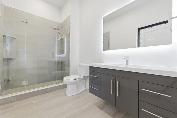 a bathroom with a sink a toilet and shower