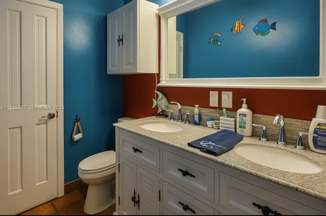 a bathroom with a granite countertop sink a toilet and a mirror