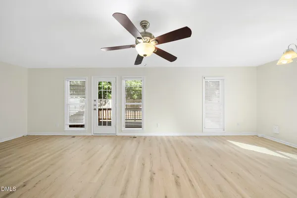 an empty room with a fireplace and chandelier