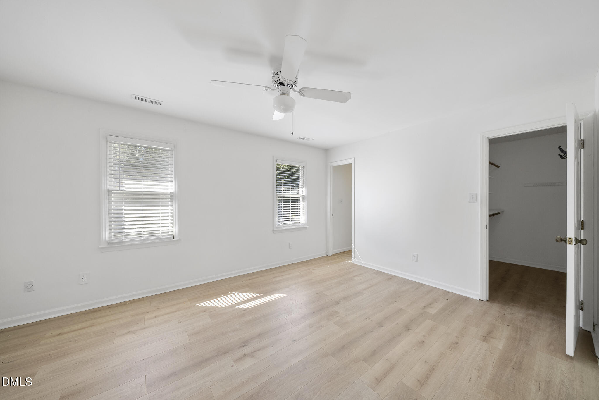 6108 New Market Way Raleigh, NC 27609 - Photo 21 of 31 an empty room with wooden floor ceiling fan and windows