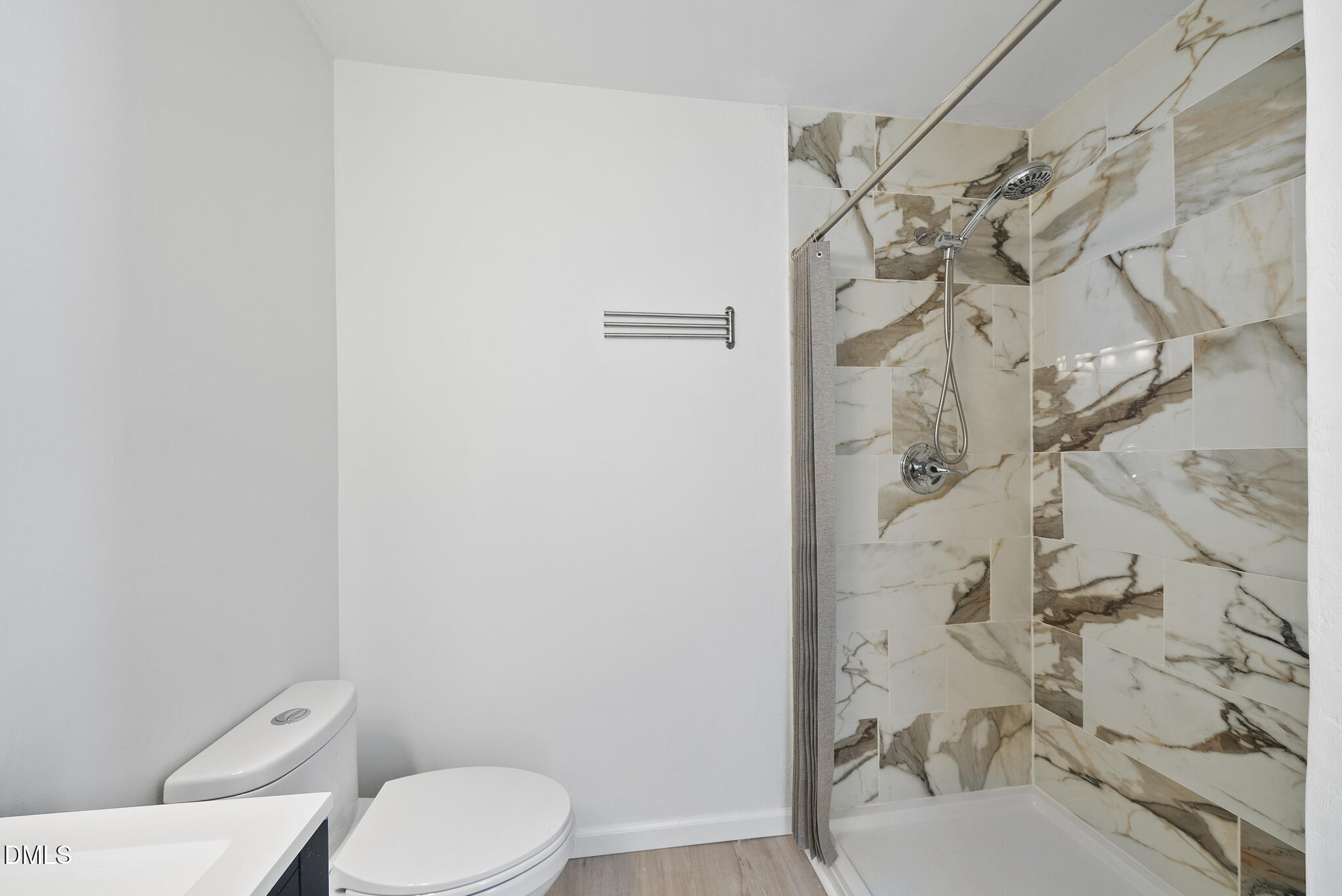 6108 New Market Way Raleigh, NC 27609 - Photo 26 of 31 a white toilet sitting next to a shower curtain