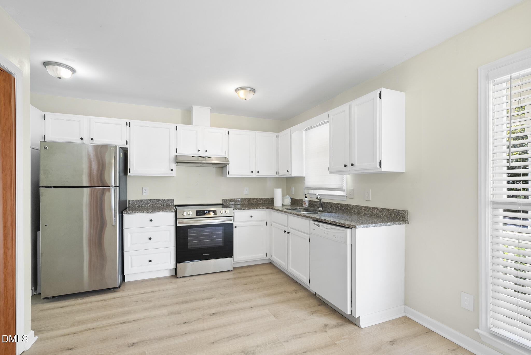6108 New Market Way Raleigh, NC 27609 - Photo 6 of 31 a kitchen with granite countertop a refrigerator stove top oven and sink