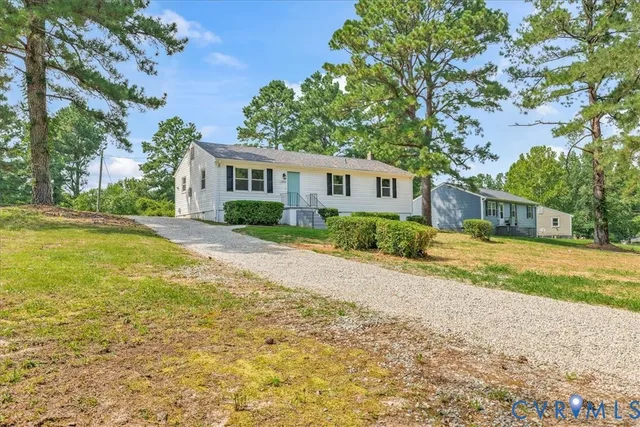 a front view of house with yard and trees around