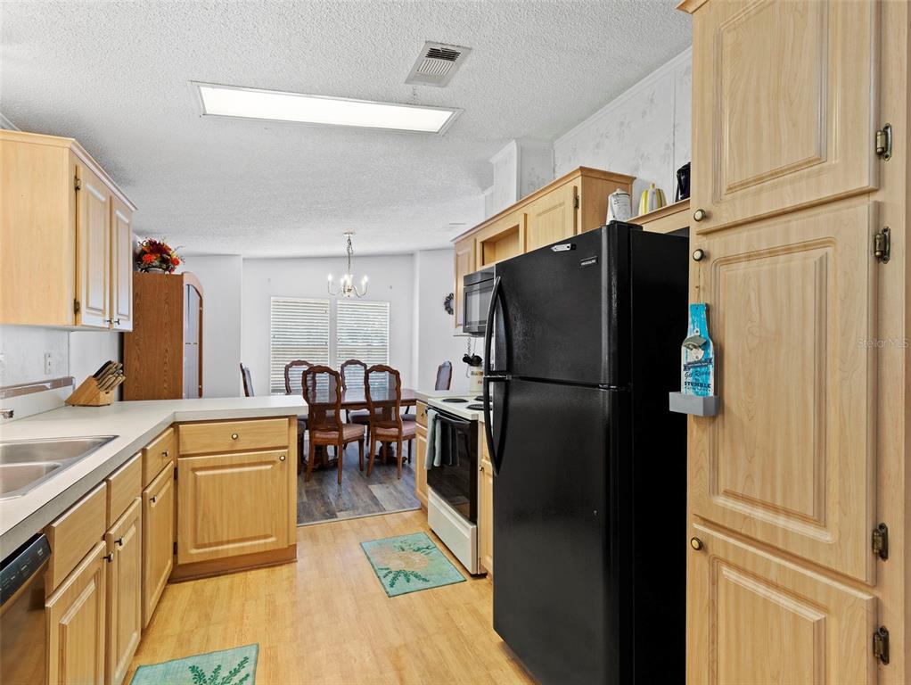 6297 Fine Street Weeki Wachee, FL 34607 - Photo 14 of 52 a kitchen with stainless steel appliances a refrigerator and a stove top oven