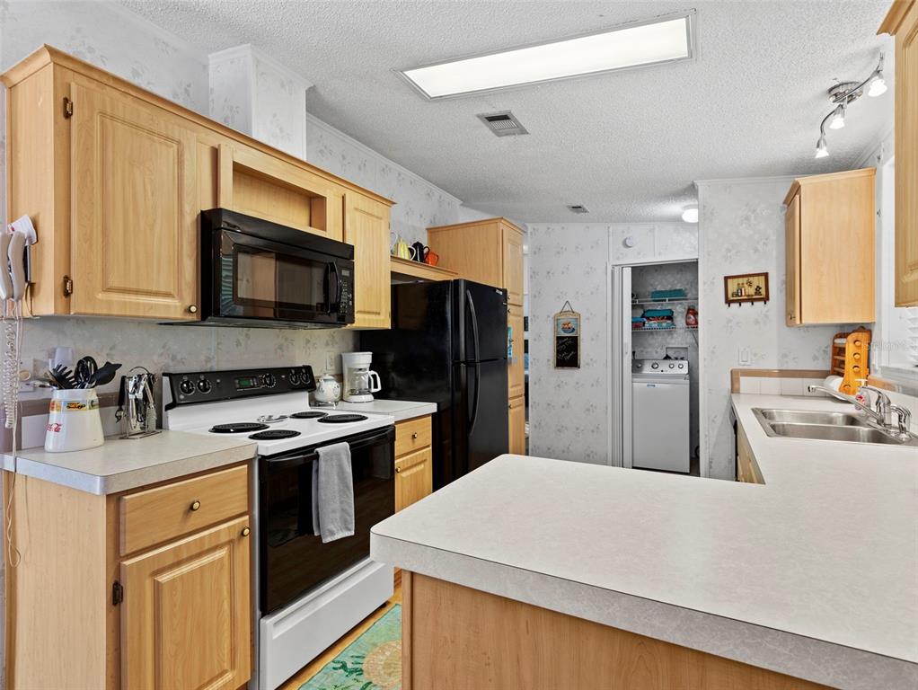 6297 Fine Street Weeki Wachee, FL 34607 - Photo 16 of 52 a kitchen with stainless steel appliances granite countertop a refrigerator stove microwave sink and cabinets