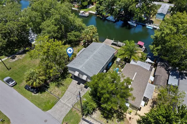 an aerial view of a house with swimming pool and outdoor seating