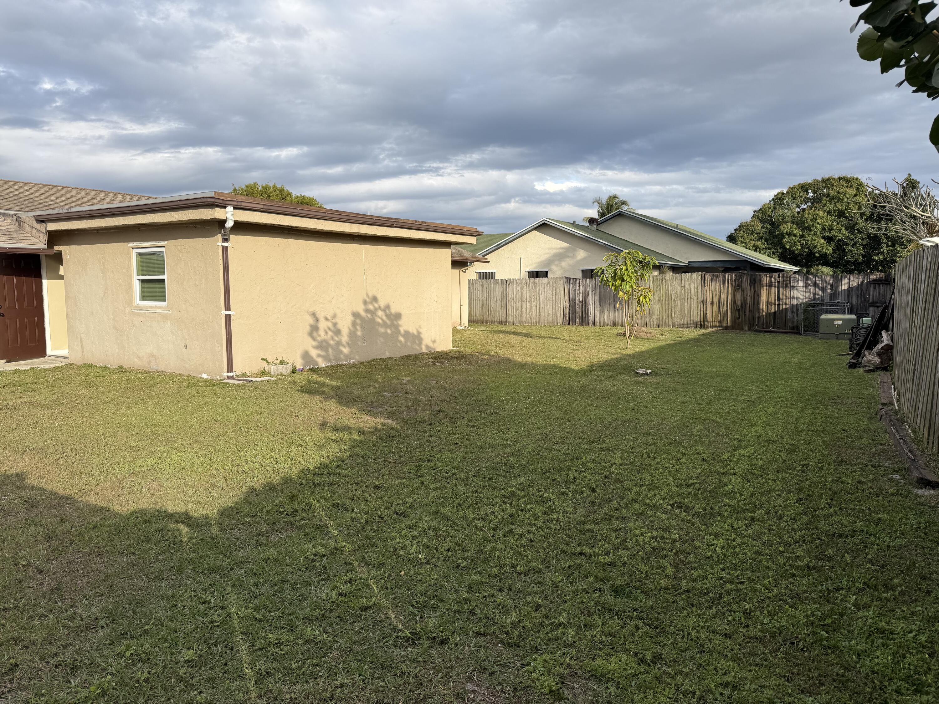 4941 Marbella Road North West Palm Beach, FL 33417 - Photo 2 of 12 a front view of a house with a yard
