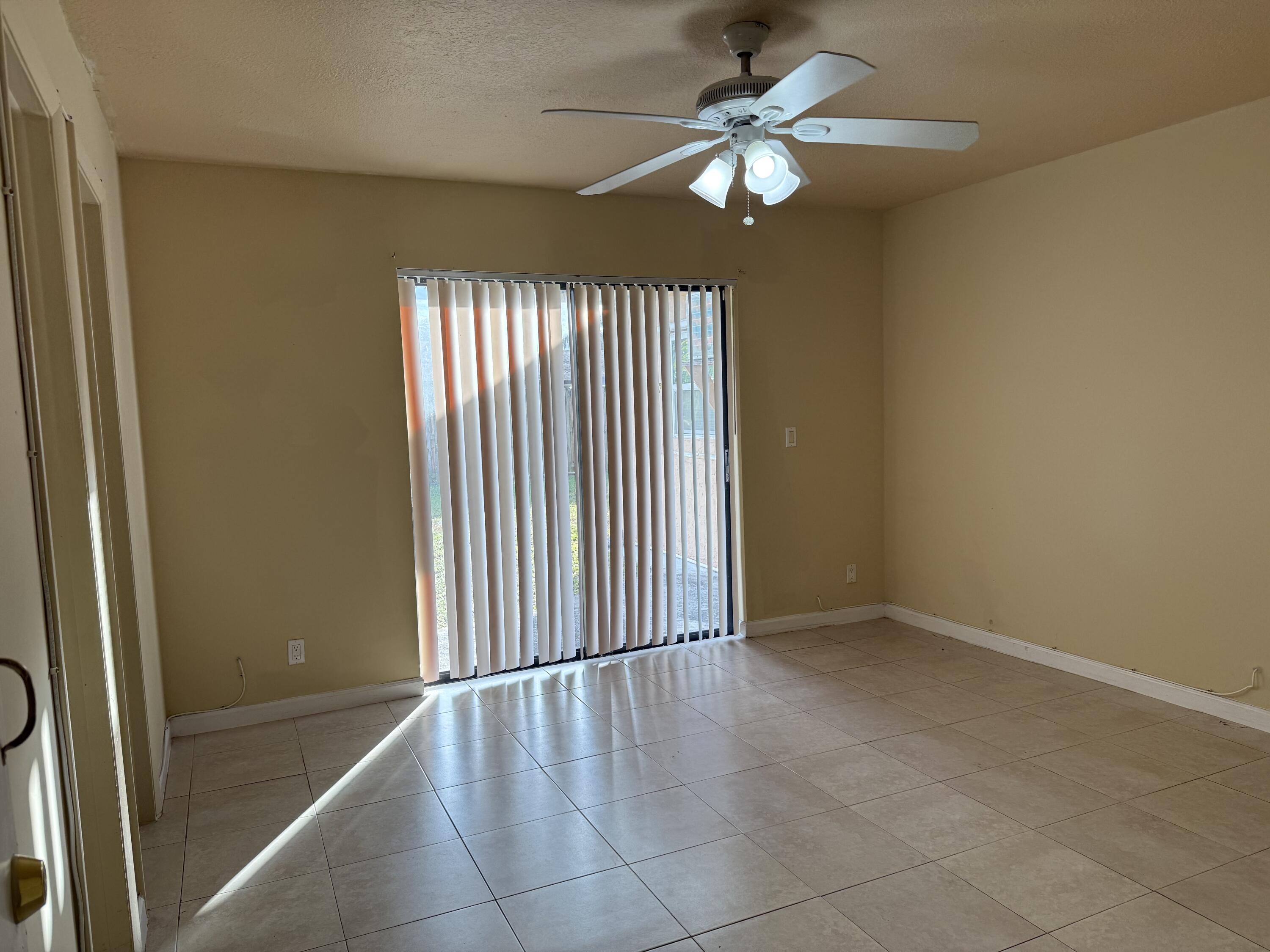 4941 Marbella Road North West Palm Beach, FL 33417 - Photo 5 of 12 en empty room with windows and fan
