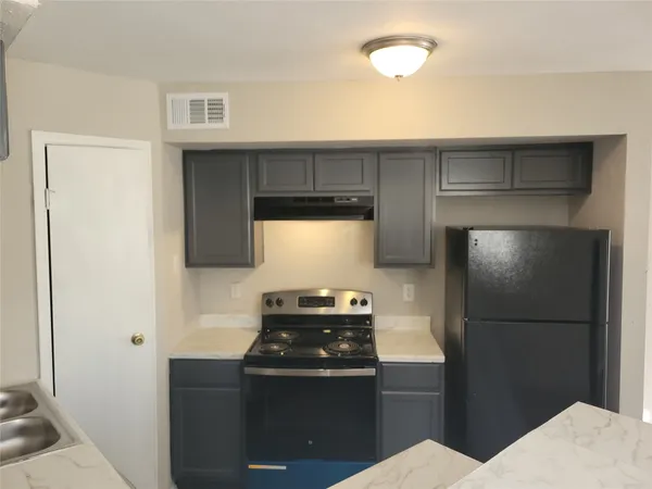 a kitchen with a refrigerator and a stove