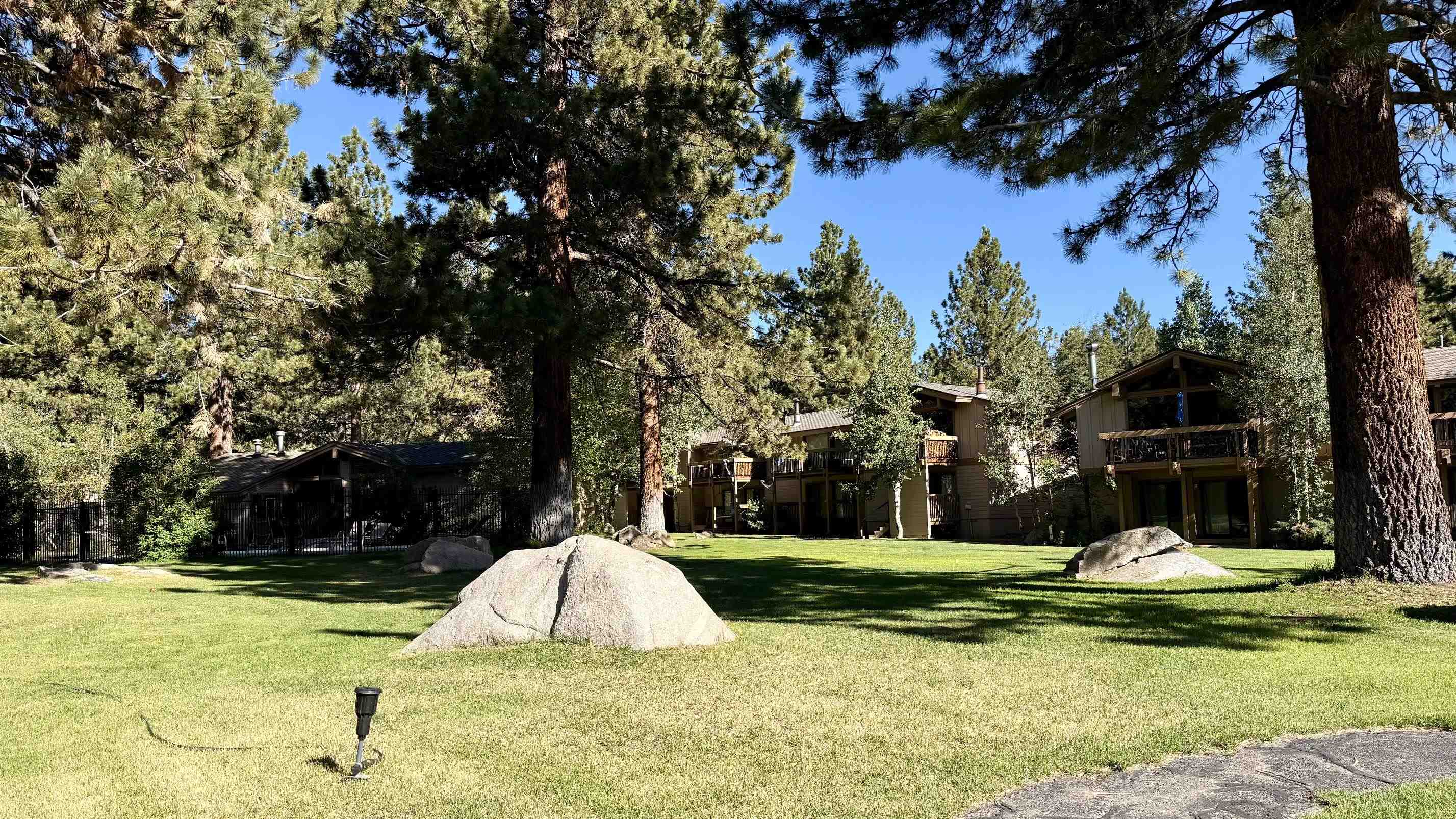3252 Chateau Road, Unit 22 Mammoth Lakes, CA 93546 - Photo 40 of 46 Expansive green lawn with mature pine trees and natural rock formations