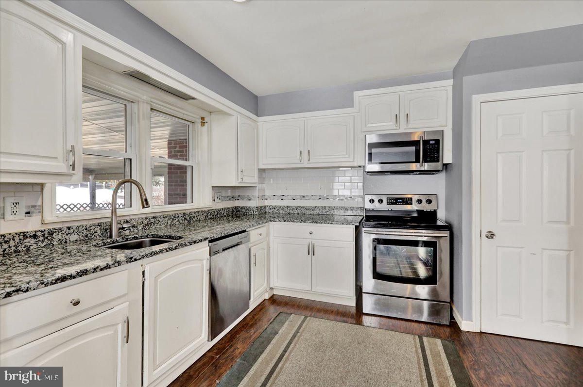 212 Mayer Street Reading, PA 19606 - Photo 14 of 37 a kitchen with stainless steel appliances granite countertop a stove sink and cabinets